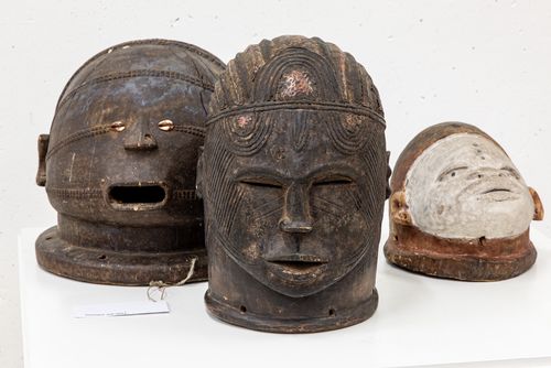 Tabwa Maske (D.R. Kongo) Holz, Kauris; Igala Helmmaske (Nigeria) Holz, Metal, Farbe; Makonde Helmmakse (Mosambik / Tansania) Holz